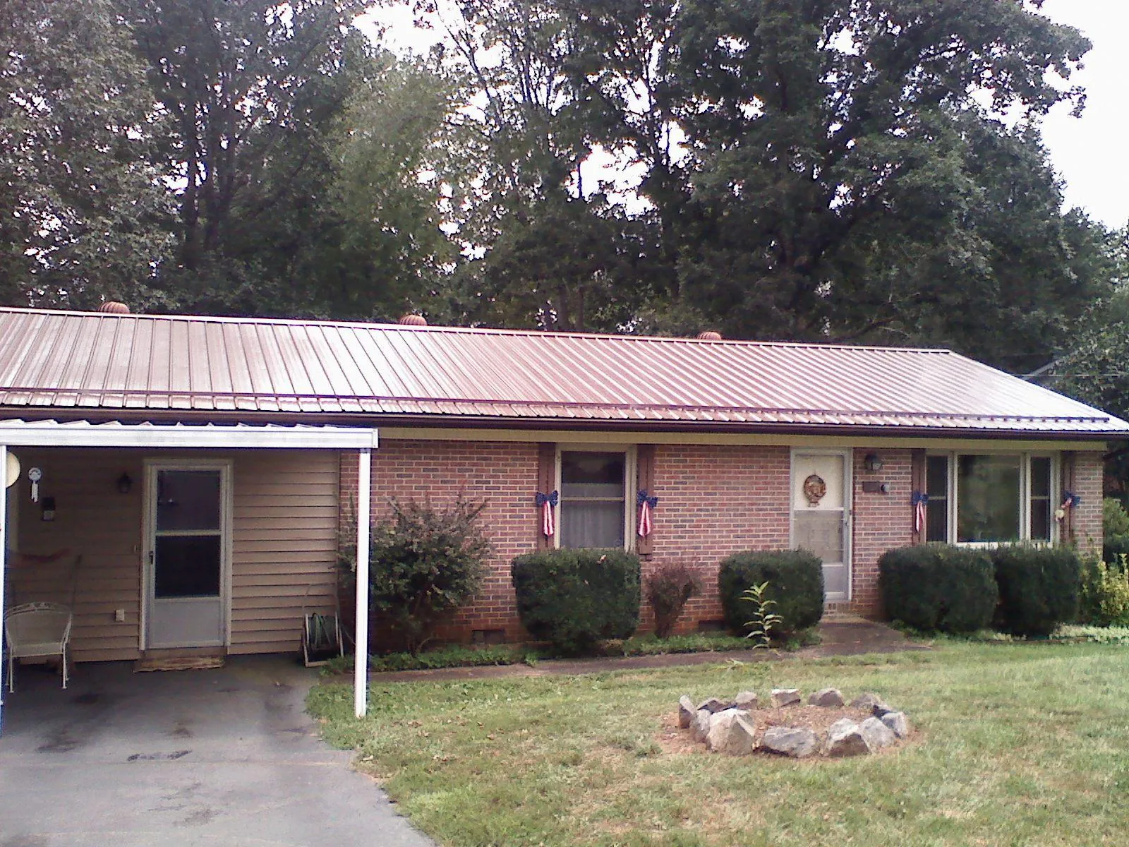 Bronze metal roof and carport on a brick ranch home — Roof Repair work by our crew in California